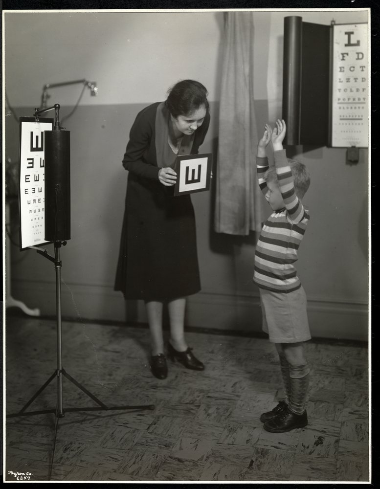 Krankenschwester und ein Junge, der einen Sehtest im New York Association for the Blind, 111 East 59th Street, New York, 1930, macht von Byron Company