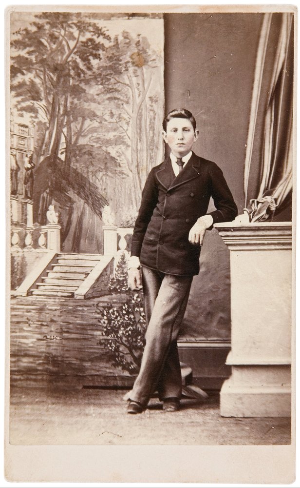 Studio-Porträt eines jungen Mannes vor gemaltem Hintergrund mit Treppe und Garten von William Bentley