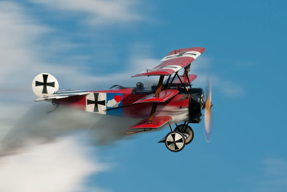Historischer roter Dreidecker im Flug von Darek Siusta