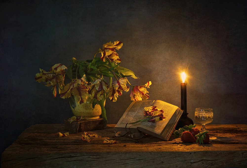 Kerzenbeleuchtetes Buch und Blumen von Saskia Dingemans