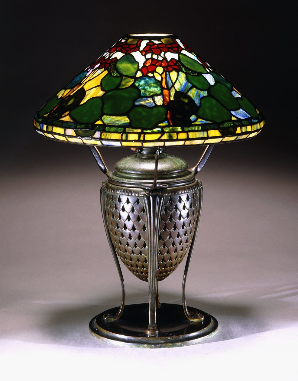 Ein "Geranium" Tischlampe mit konischem Schirm und durchbrochenem Bronzeurnenfuß mit Fischschuppenmuster, 20. Jahrhundert von American School