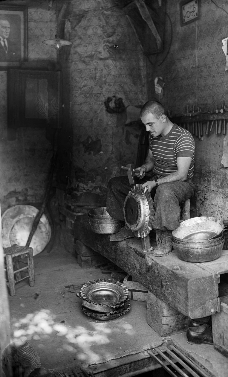 Italienischer Metallarbeiter hämmert auf ein Formblech, um ein erhöhtes Gefäß oder einen Topf herzustellen, Italien von Bernard F. Rogers