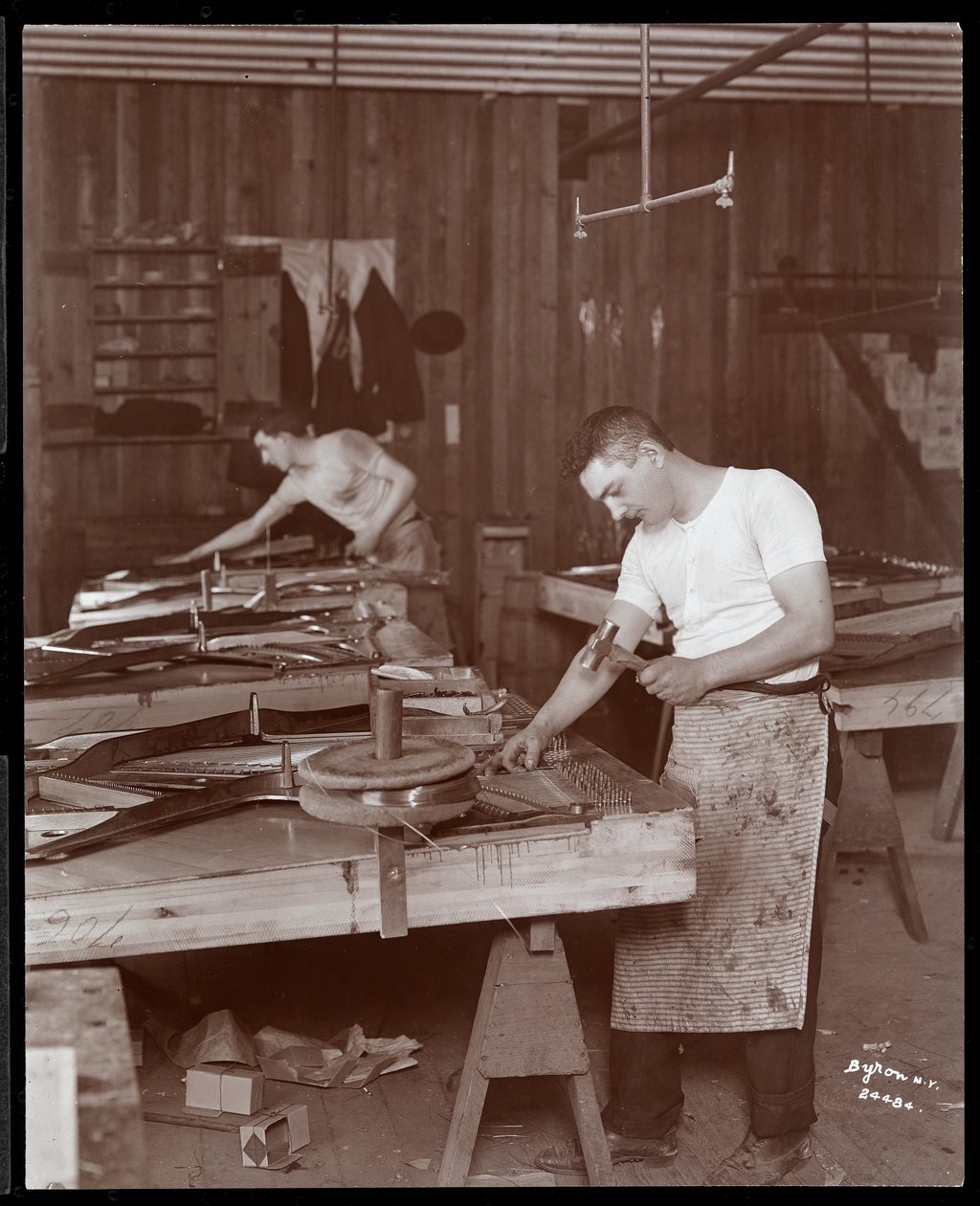 Zwei Männer arbeiten in der Harrington Piano Co. Fabrik von Byron Company
