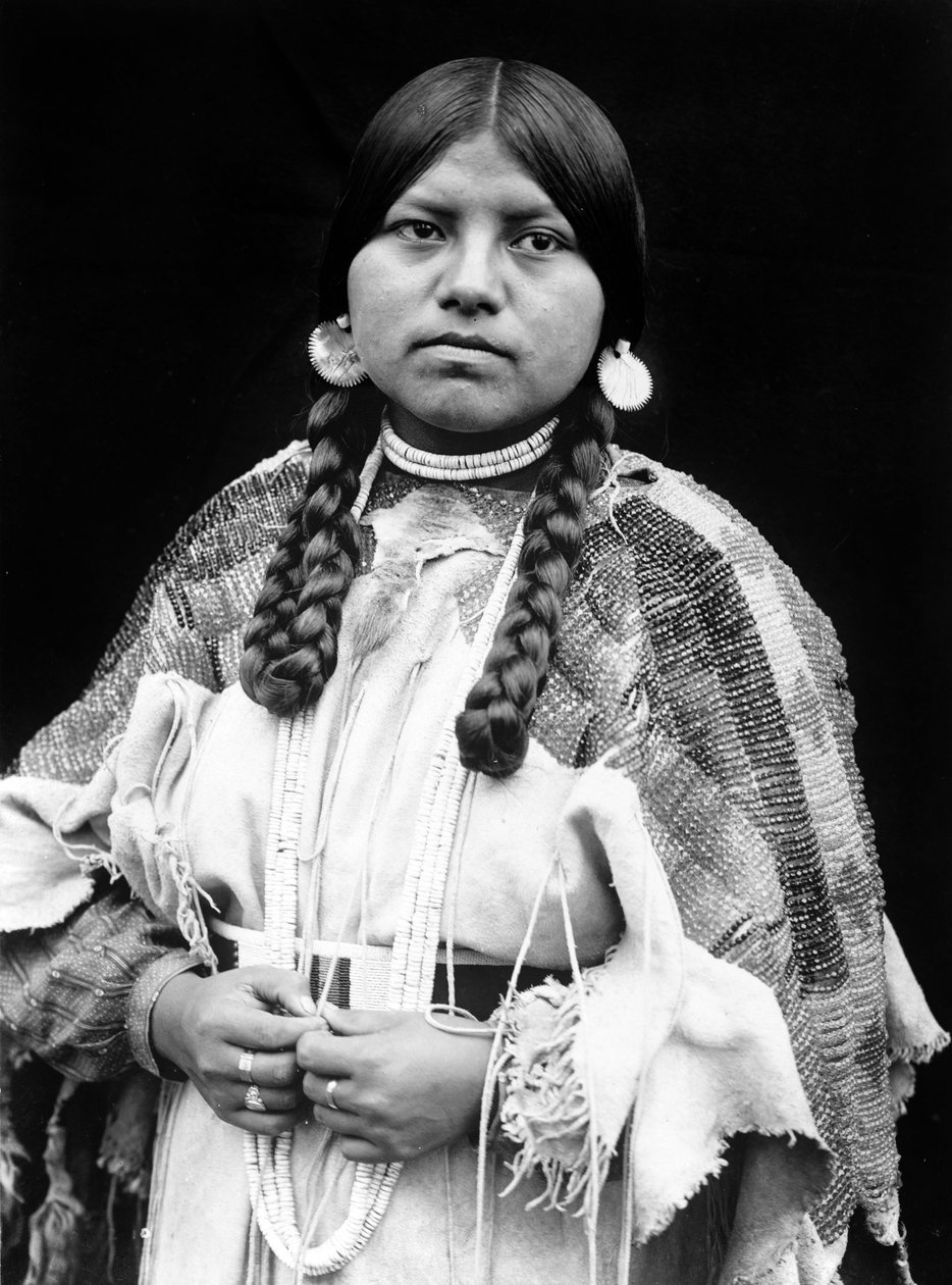 Cayuse-Frau, Halbporträt, stehend, frontal, Zöpfe, Muschelscheiben-Ohrringe, Muschelperlen-Halsband und Muschelperlen um den Hals, Perlen-Wildlederkleid mit Perlengürtel ca. 1910, Foto Edward S. Curtis von Edward Sheriff Curtis