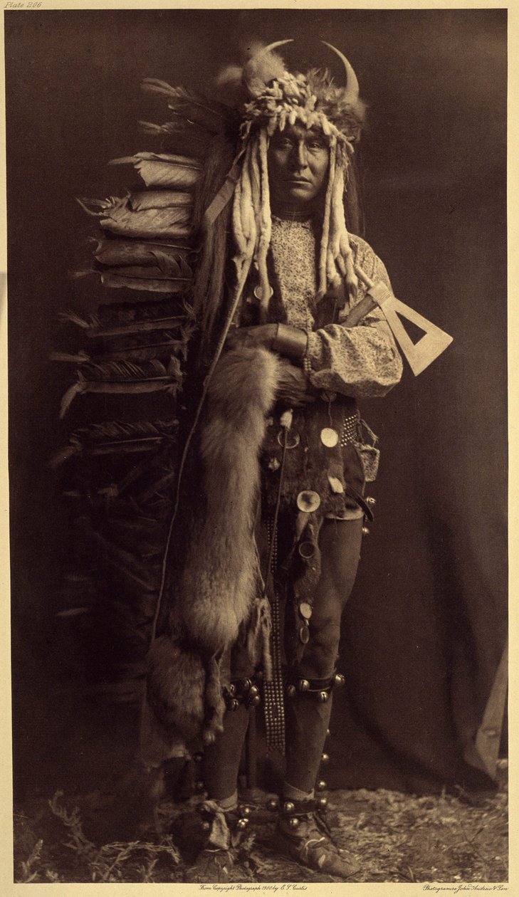 Eisenbrust, Piegan. Kostüm eines Mitglieds der Bullen, einer ehemaligen Gesellschaft, die seit vielen Jahren verschwunden ist. Foto aus Band 6 der Enzyklopädie von Edward S. Curtis (1868-1952) über die Indianer Nordamerikas von Edward Sheriff Curtis