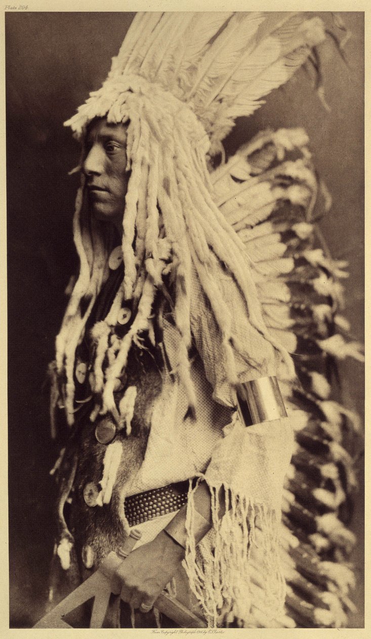 Alter Mensch, Piegan. Junge Männer verpassen keine Gelegenheit, bei öffentlichen Festen die Kleidung ihrer Krieger-Väter zu tragen. Foto aus Band 6 der Enzyklopädie von Edward S. Curtis (1868-1952) über die Indianer Nordamerikas von Edward Sheriff Curtis