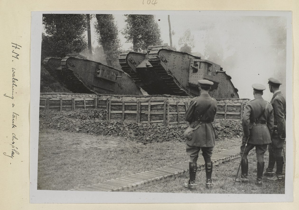 Drei Offiziere, einer möglicherweise König Georg V., beobachten zwei Panzer, die über ein Hindernis fahren, 1915-18 von English Photographer