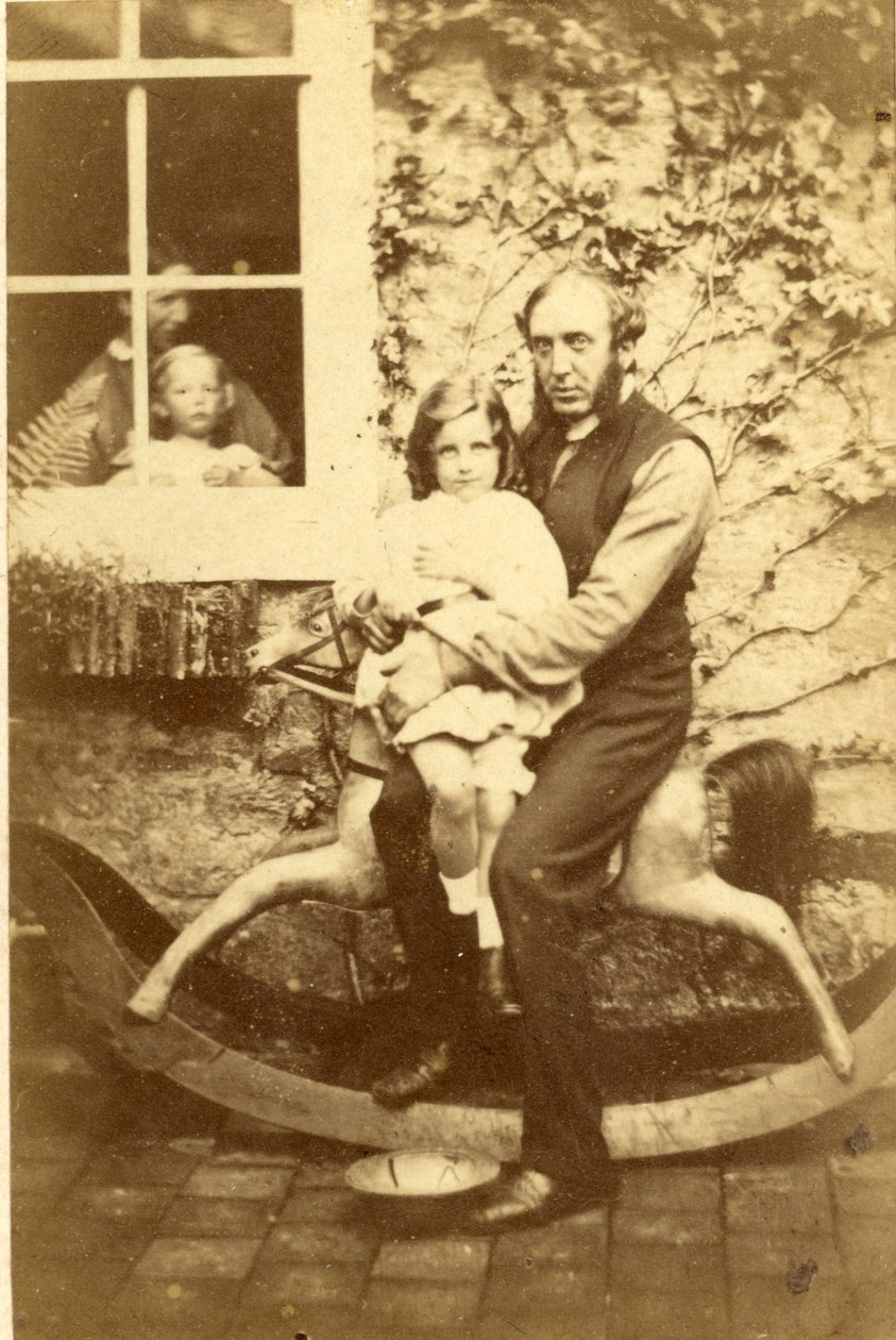 Vater und Tochter auf einem Schaukelpferd mit Bruder und Mutter, die durch das Fenster schauen, 1860er Jahre von English Photographer