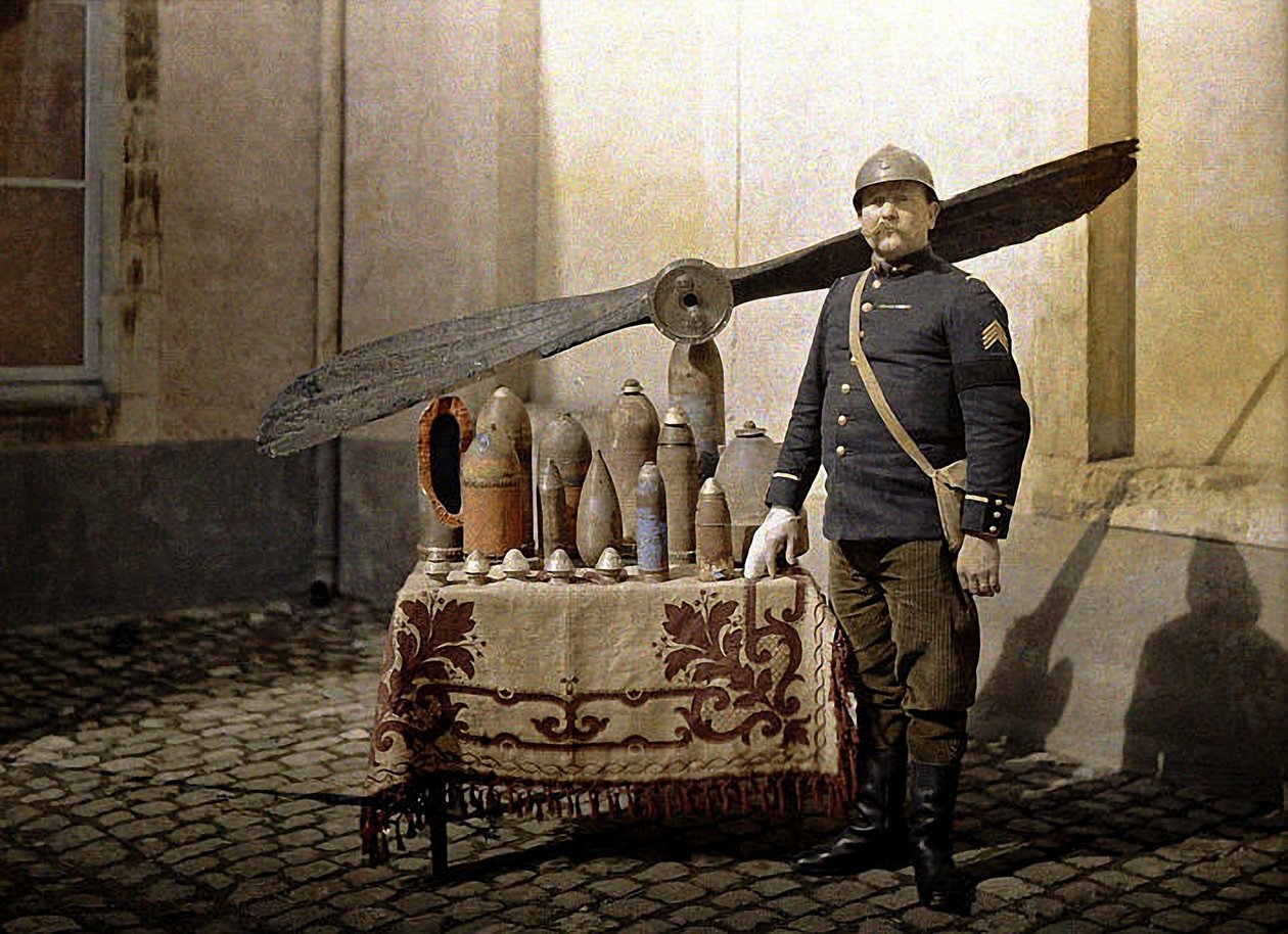 Ein französischer Soldat neben einem Tisch mit deutschen Granaten und einem Flugzeugpropeller, Reims, Marne, 1917 von Fernand Cuville