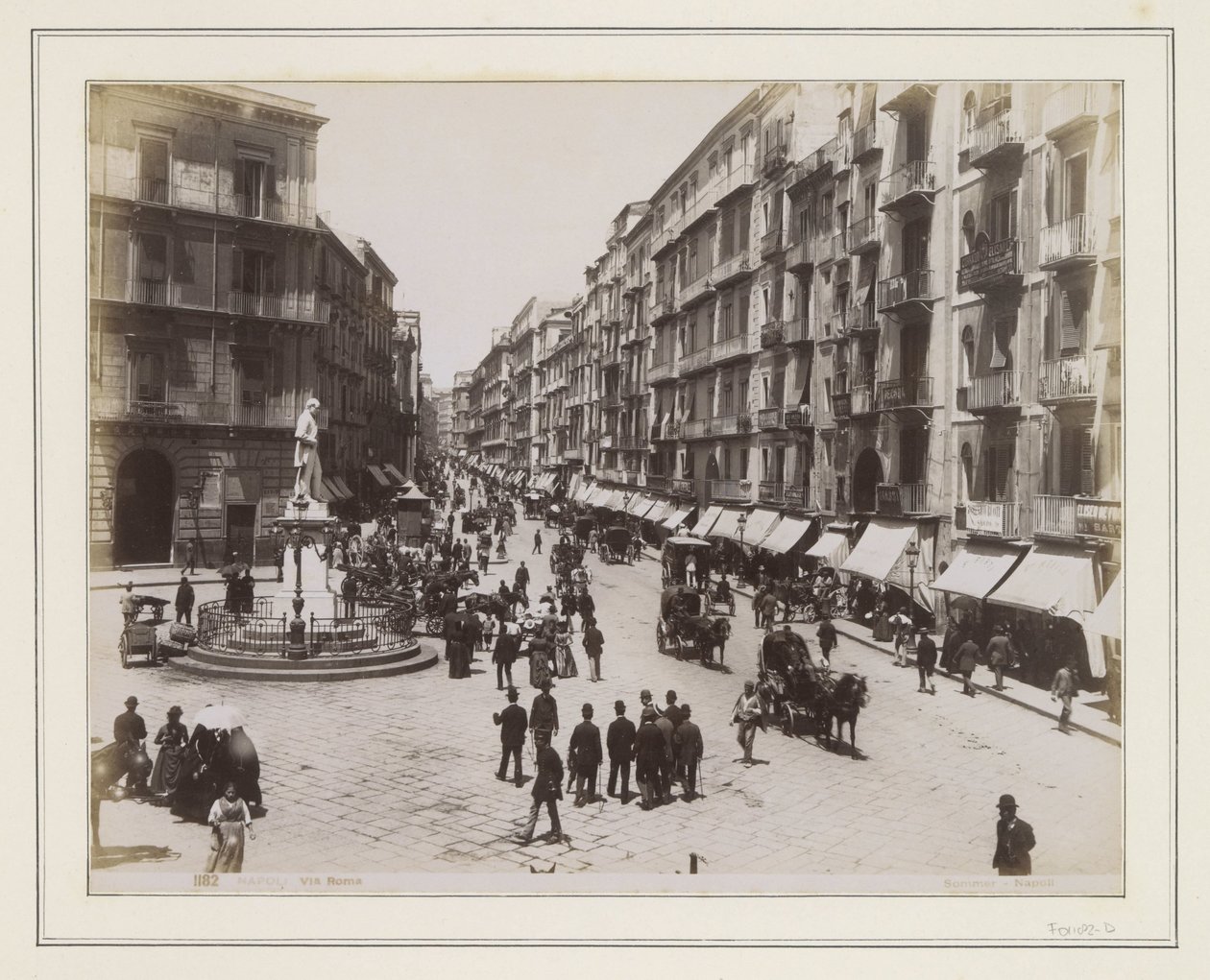 Ansicht der Via Roma in Neapel mit einer Statue, Geschäften, Pferdekutschen und Passanten von Giorgio Sommer