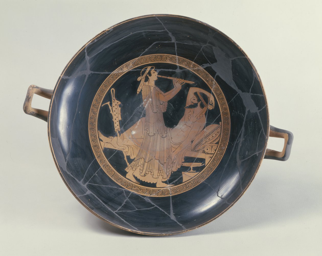 Attische rotfigurige Schale, die eine Frau zeigt, die eine Doppelflöte spielt von Greek