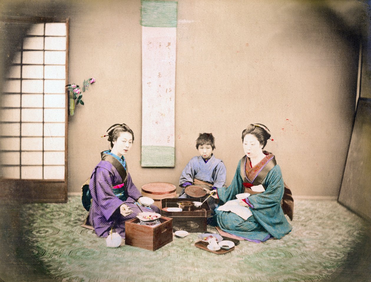 Zwei Frauen und ein Kind beim Mittagessen, sitzend auf einer Matte von Japanese Photographer
