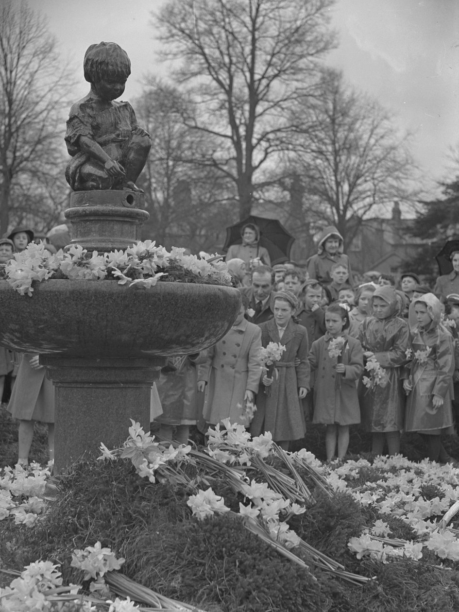 Kinder legen Narzissensträuße auf einen Brunnen mit Statue oben von Joseph Hardman
