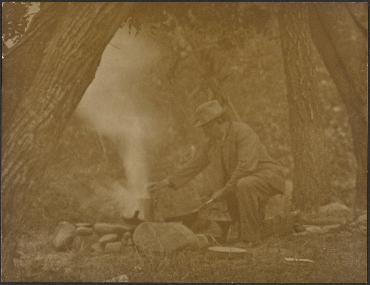 [Mann kocht am Lagerfeuer im Wald] von Louis Fleckenstein