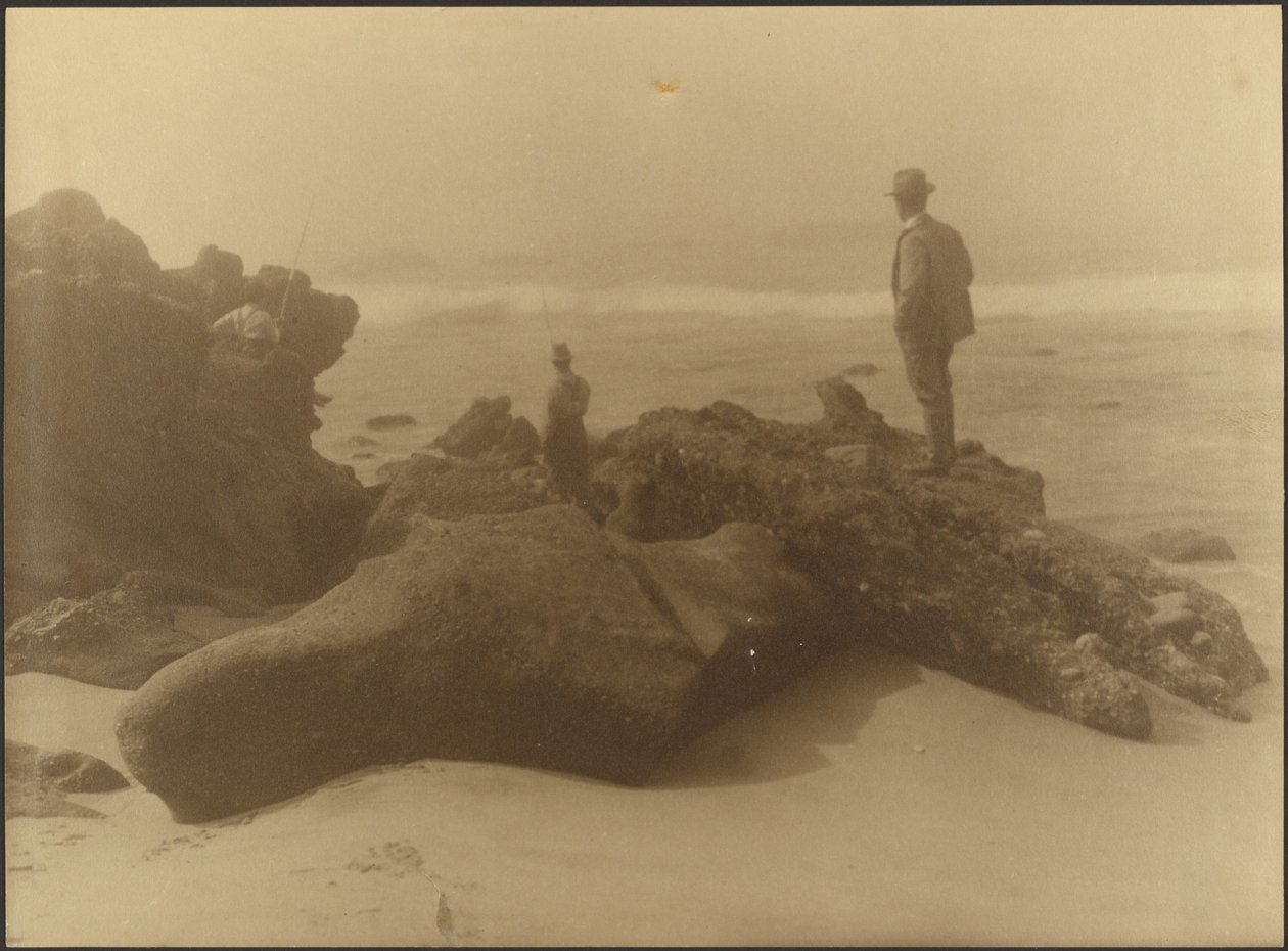 Drei Männer angeln von Felsen am Strand von Louis Fleckenstein
