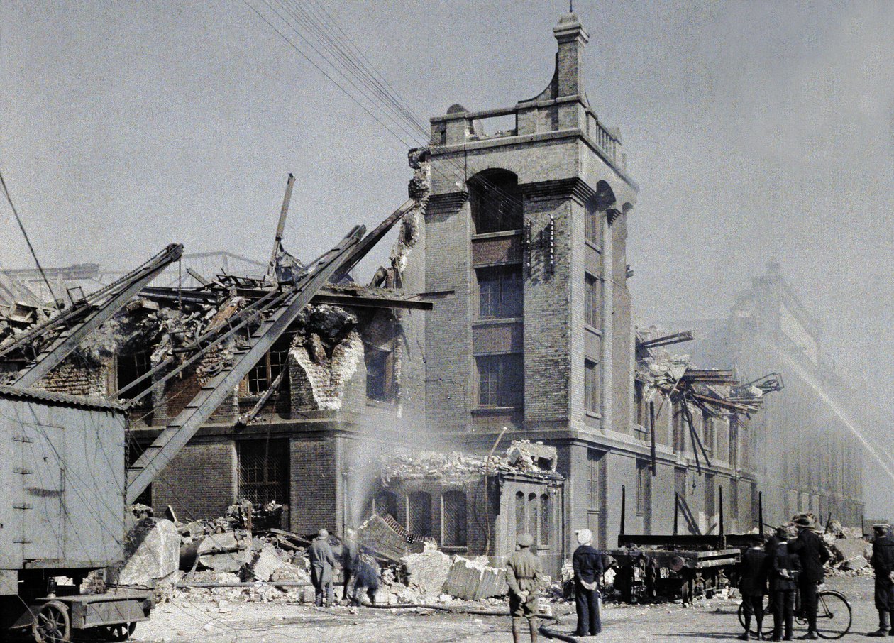 Französische Feuerwehrleute, Militärs und Zivilisten versuchen, nach den Bombenangriffen vom 2. und 3. September, die mehrere Gebäude in Dünkirchen, einschließlich des Lagers Ba, betroffen haben, Brände zu verhindern von Paul Castelnau
