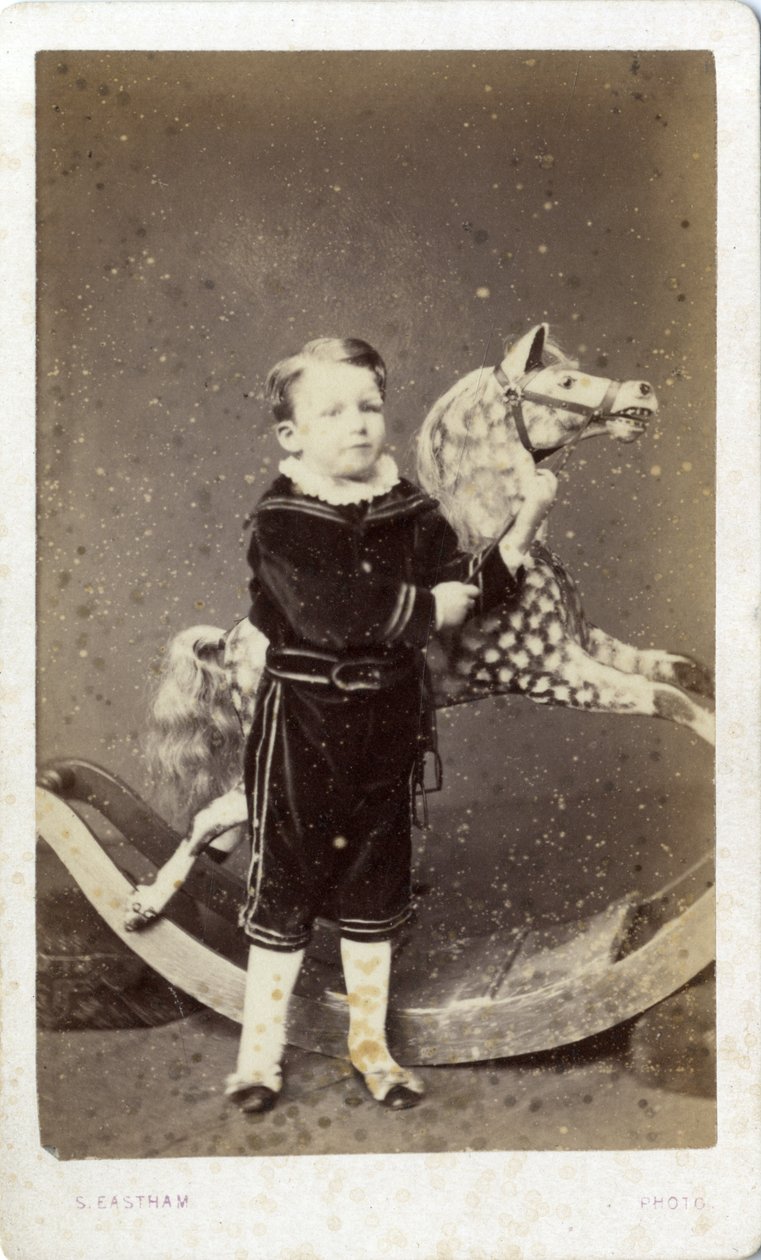 Junger Junge neben einem Schaukelpferd von Silas Eastham