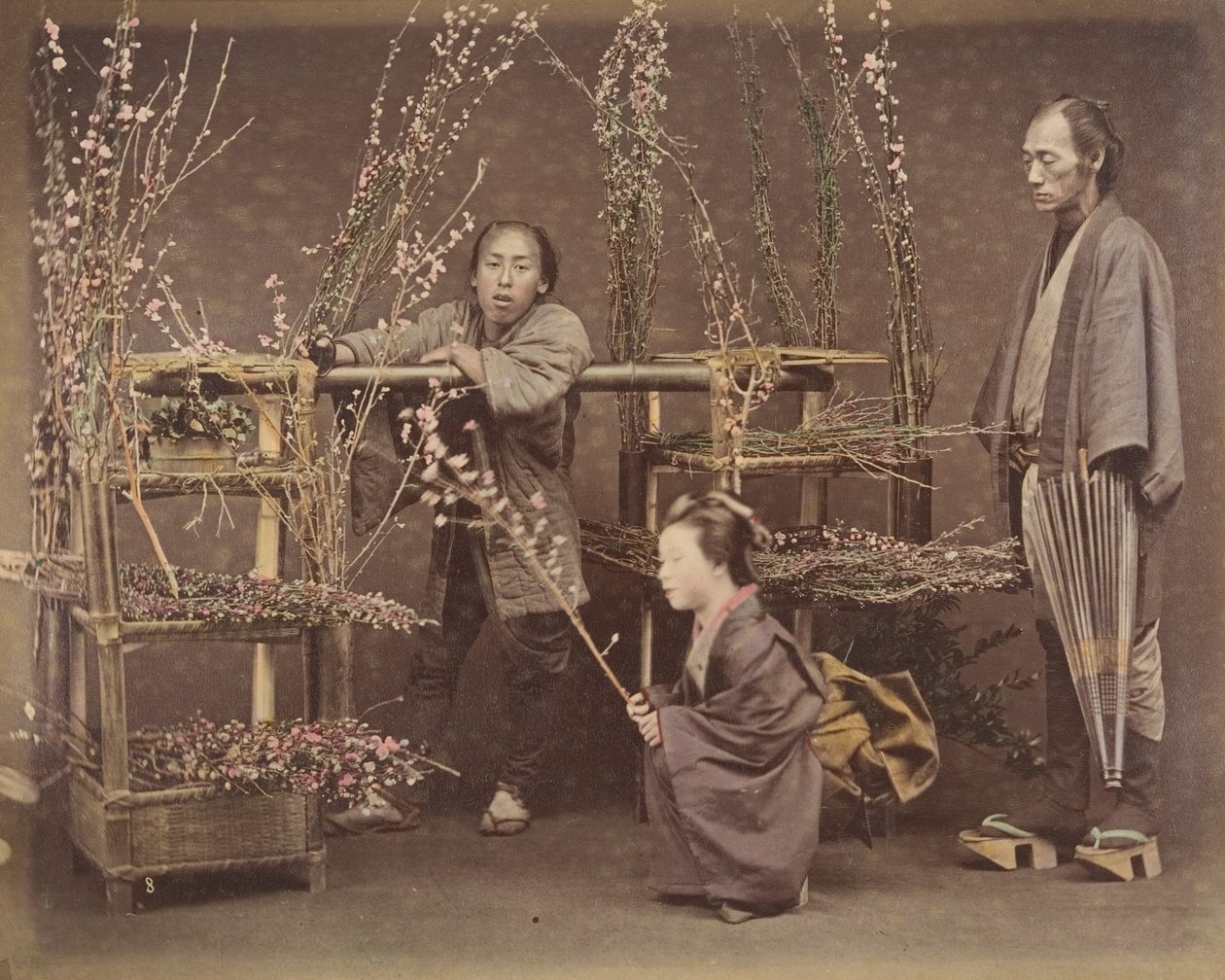 [Zwei japanische Männer und eine japanische Frau posieren mit blühenden Zweigen], 1870er Jahre von Unbekannt
