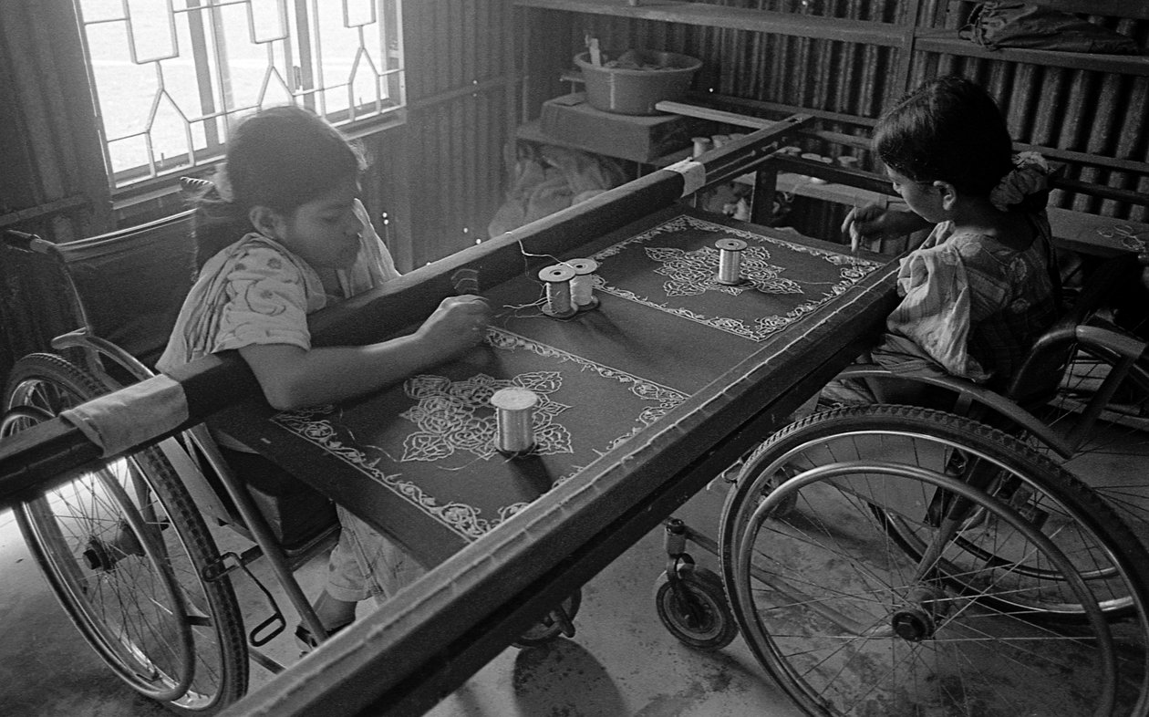 Zwei körperlich behinderte Mädchen sticken Kleidung im Zentrum für die Rehabilitation der Gelähmten, CRP in Savar, Dhaka, Bangladesch. 2005. von Unbekannt Unbekannt