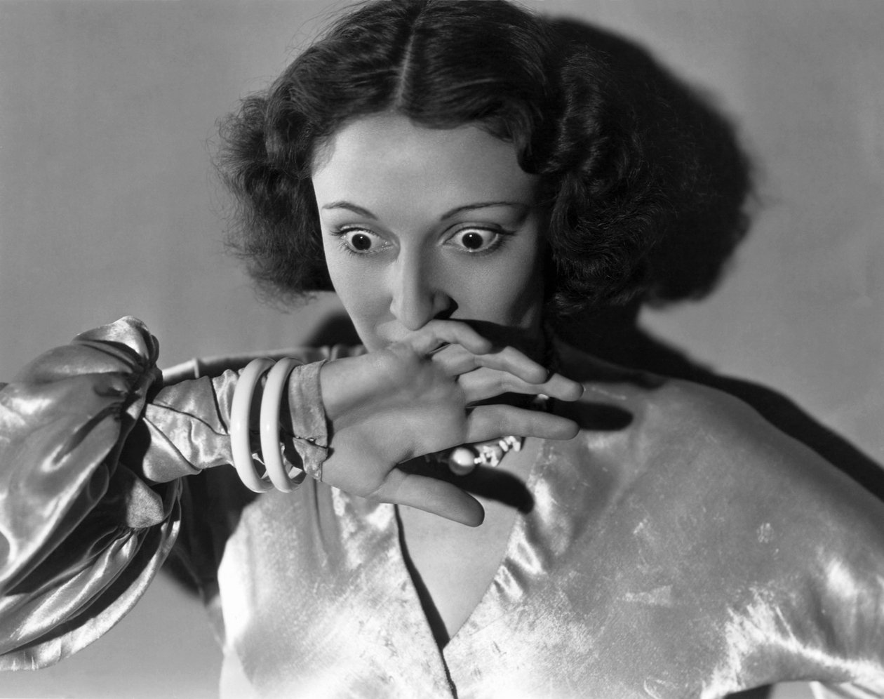 Hollywood, Kalifornien: ca. 1932 Nahaufnahme einer jungen Frau, die sich erschrocken den Mund bedeckt. (s/w Foto) von Unbekannt
