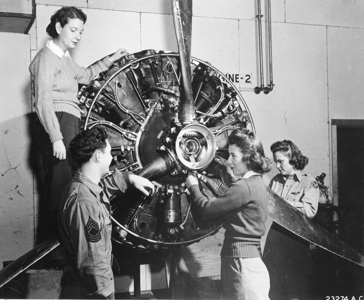 Wespen lernen, woher die Kraft im B-17 Flying Fortress-Motor kommt, während sie an der B-17-Pilotenausbildung auf dem Lockbourne AAB teilnehmen. Sie arbeiten am Propellermechanismus, während ein Crew-Chief zusieht. Sie sind (v.l.n.r.): Patricia Bowser, Ann von Benjamin Baud