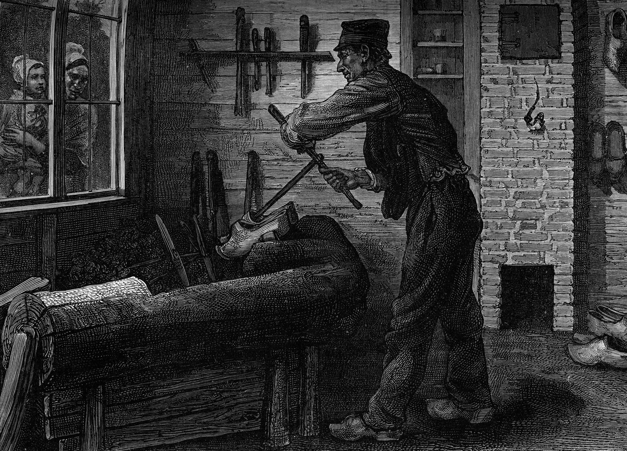 Ein Holzschuhmacher bei der Arbeit in seiner Werkstatt in Belgien. Gravur in der Zeitschrift „la jeunesse“ von Unknown artist