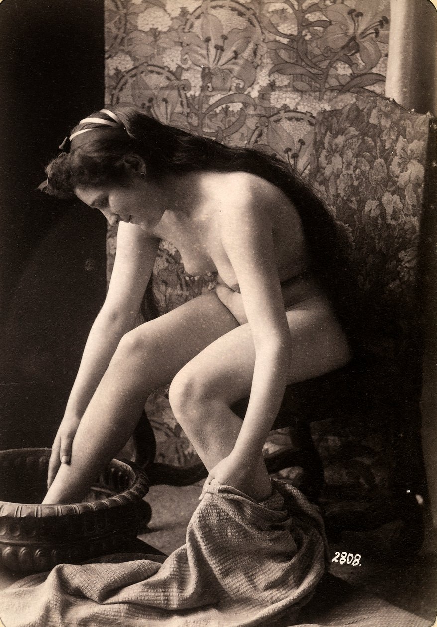 Porträt einer nackten Frau, die ihre Füße wäscht von Unknown photographer