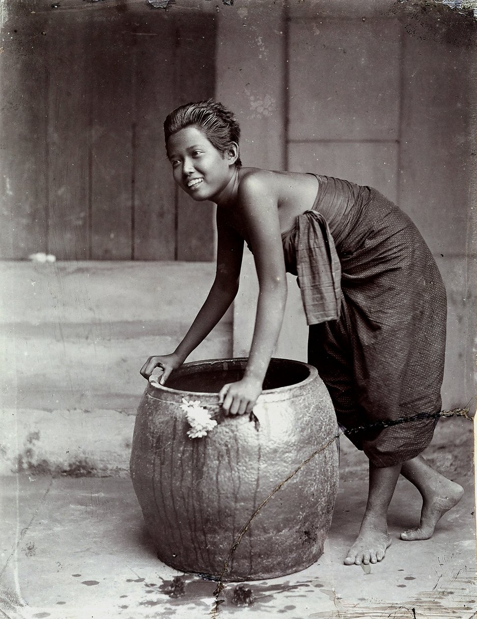 Junge lächelnde thailändische Frau, die einen großen Behälter schiebt von Unknown photographer