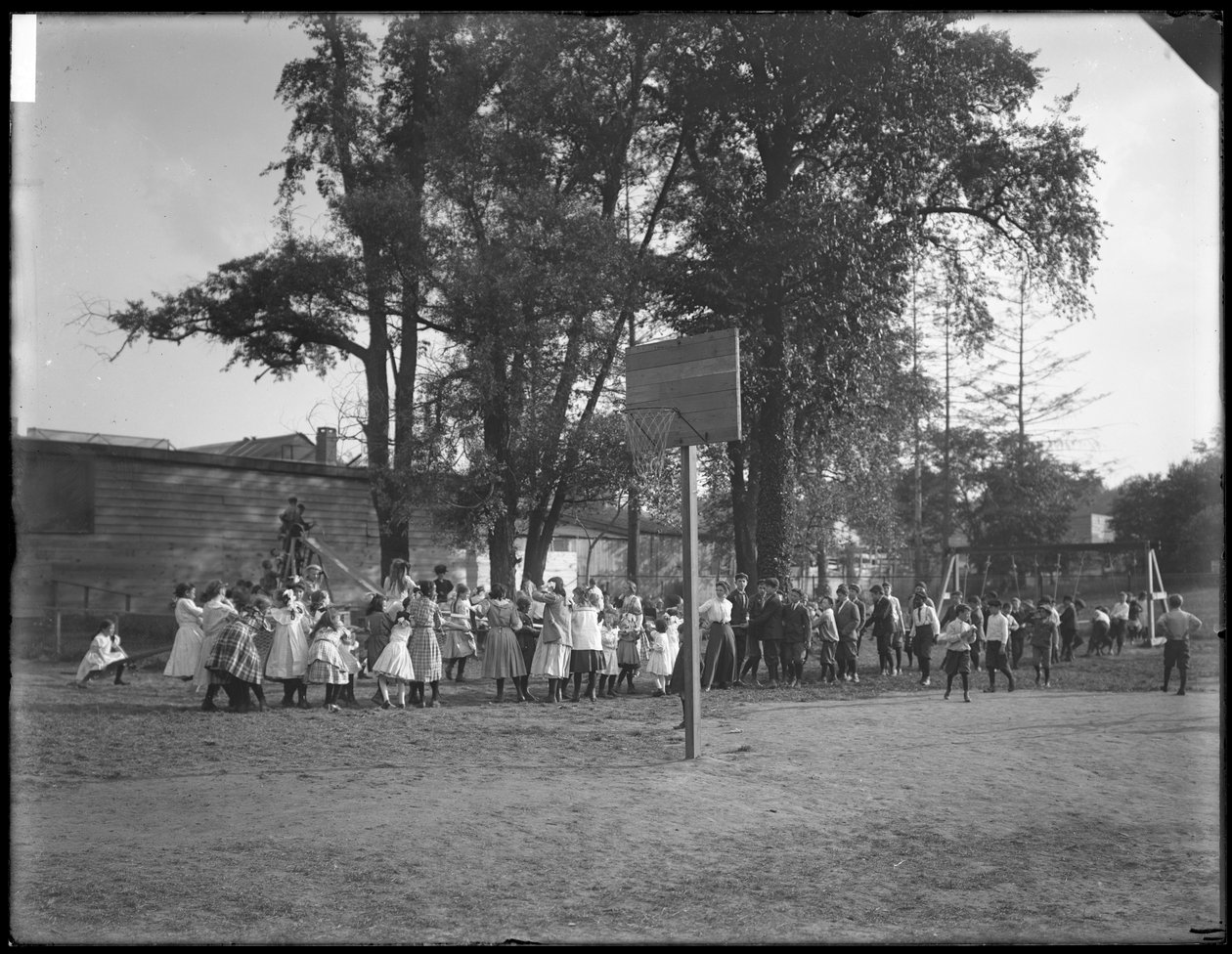 Jungen und Mädchen spielen Tauziehen auf einem unbekannten Spielplatz, ca. 1910 von William Davis Hassler