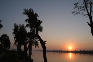 Goldene Sonnenuntergangsreflexionen auf einem ruhigen Fluss von Albert Mansour