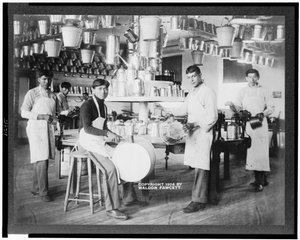 Junge amerikanische Ureinwohner in einer Metallwerkstatt mit Eimern, Waschwannen, Gießkannen und anderen Metallgegenständen, Carlisle Indian School, Pennsylvania, ca. 1904 (s/w Foto) von American Photographer