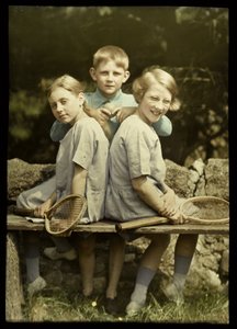 Porträt von zwei Mädchen mit Tennisschlägern und einem Jungen mit Tennisball