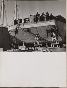 Eine Gruppe von Männern arbeitet an einem angedockten Boot von Arnold Eagle