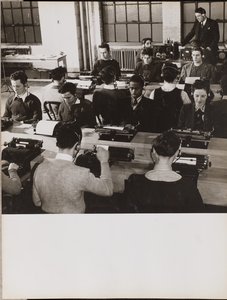 Menschen sitzen vor Schreibmaschinen und tragen Kopfhörer von Arnold Eagle