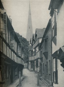 Schöne Häuser versammeln sich um einen Kirchturm, der zum Himmel zeigt, um 1935