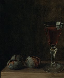 Ein Glas Wein mit Walnüssen auf einem Tisch