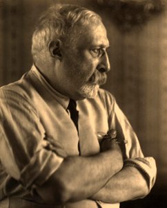 Profilporträt des Malers Arturo Rietti mit verschränkten Armen
