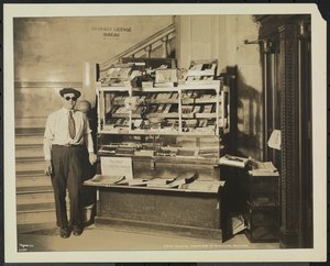 Blinder Zeitungsverkäufer, John Martie, an seinem Stand am südlichen Ende des Municipal Building, New York