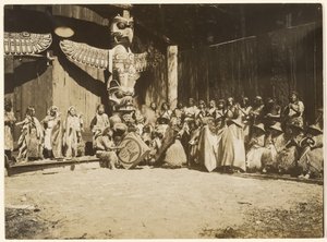 [Dicht an die Wände gedrängt war die bunte Schar von Kriegern und ihren Frauen]