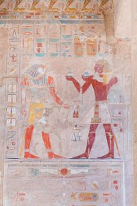 Basreliefbild, das den Pharao (rechts) zeigt, wie er dem Gott Horus Opfer darbringt, Tempel von Hatshepsut in Deir Al Bahari, Luxor, Ägypten (Foto)