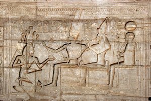 Ägyptische Antiquität: Relief, das Pharao Ramses II. vor den Gottheiten der thebanischen Triade, Amon, Mut und Khonsu darstellt; Totentempel von Ramses II., Ramesseum, Luxor, Ägypten