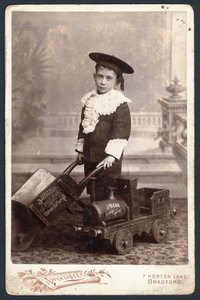 Junge mit Spielzeugzug und Schubkarre von English Photographer
