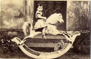 Kleines Mädchen auf einem großen Schaukelpferd im Garten, 1860er Jahre von English Photographer