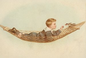 Junge, der in einer Hängematte liegt und einen Vogel füttert von European School