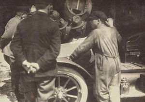 [Männer um die Motorhaube eines Autos gruppiert]
