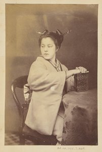 Sitzende japanische Frau mit einem Cartes-de-Visite-Album an einem Tisch von Felice Beato