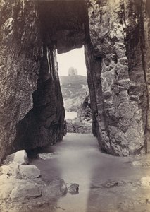 Blick durch Felsen auf einen Turm auf einem Hügel, 1870er Jahre