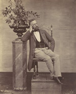 Mathias Höusermann, sitzend mit Ellbogen auf Sockel, hält eine Vase mit Blumen von Franz Antoine