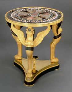 Empire-Gueridon, bestehend aus einer runden Marmortischplatte mit einem zentralen Rosettenmuster, gestützt auf den Flügeln von drei Sphinx-Monopodien, auf einem dreieckigen Ormolu-Sockel, ca. 1800