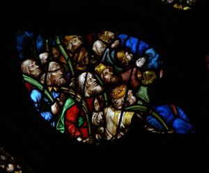 Das westliche Rosenfenster zeigt eine Szene aus dem Buch der Offenbarung: Menge vor dem Thron Gottes, in weißen Gewändern, die Palmen tragen (7:9-12). (weiße Gewänder sind hier etwas gefärbt!)